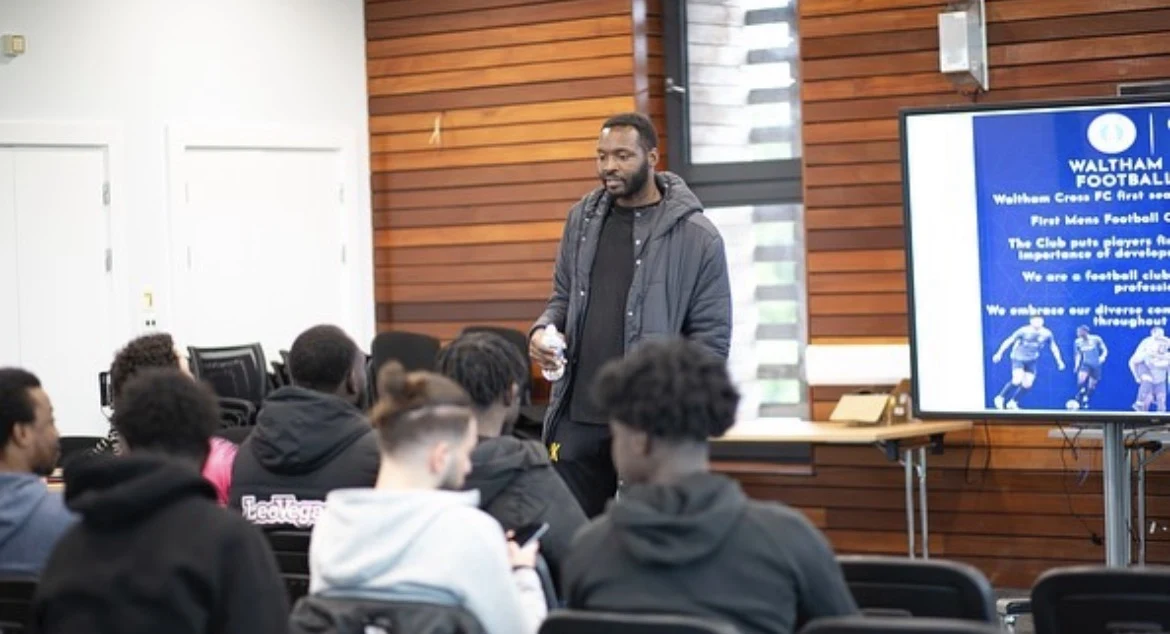 A speaker delivering a football workshop to a group