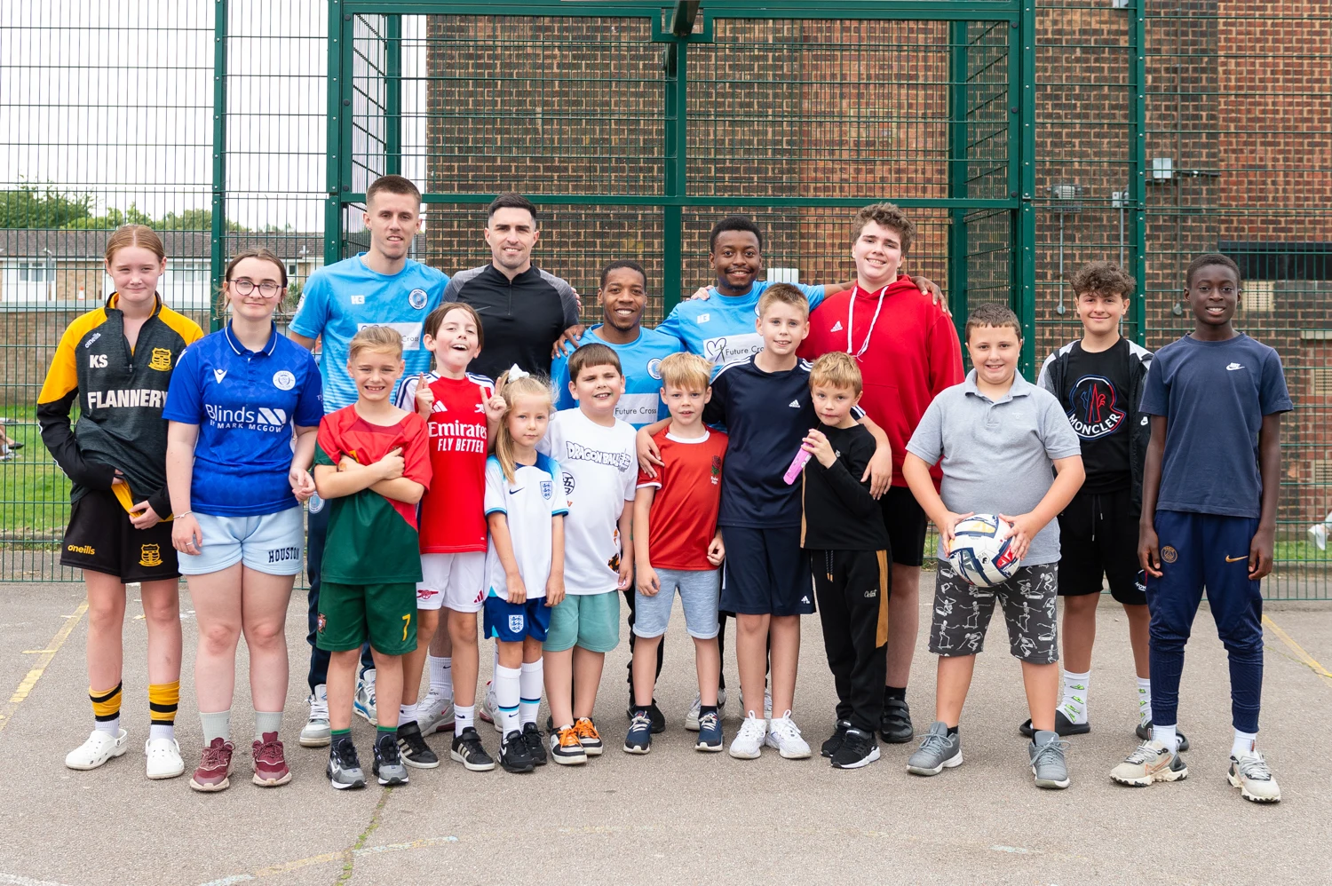Coaches and young players together on an outdoor football court