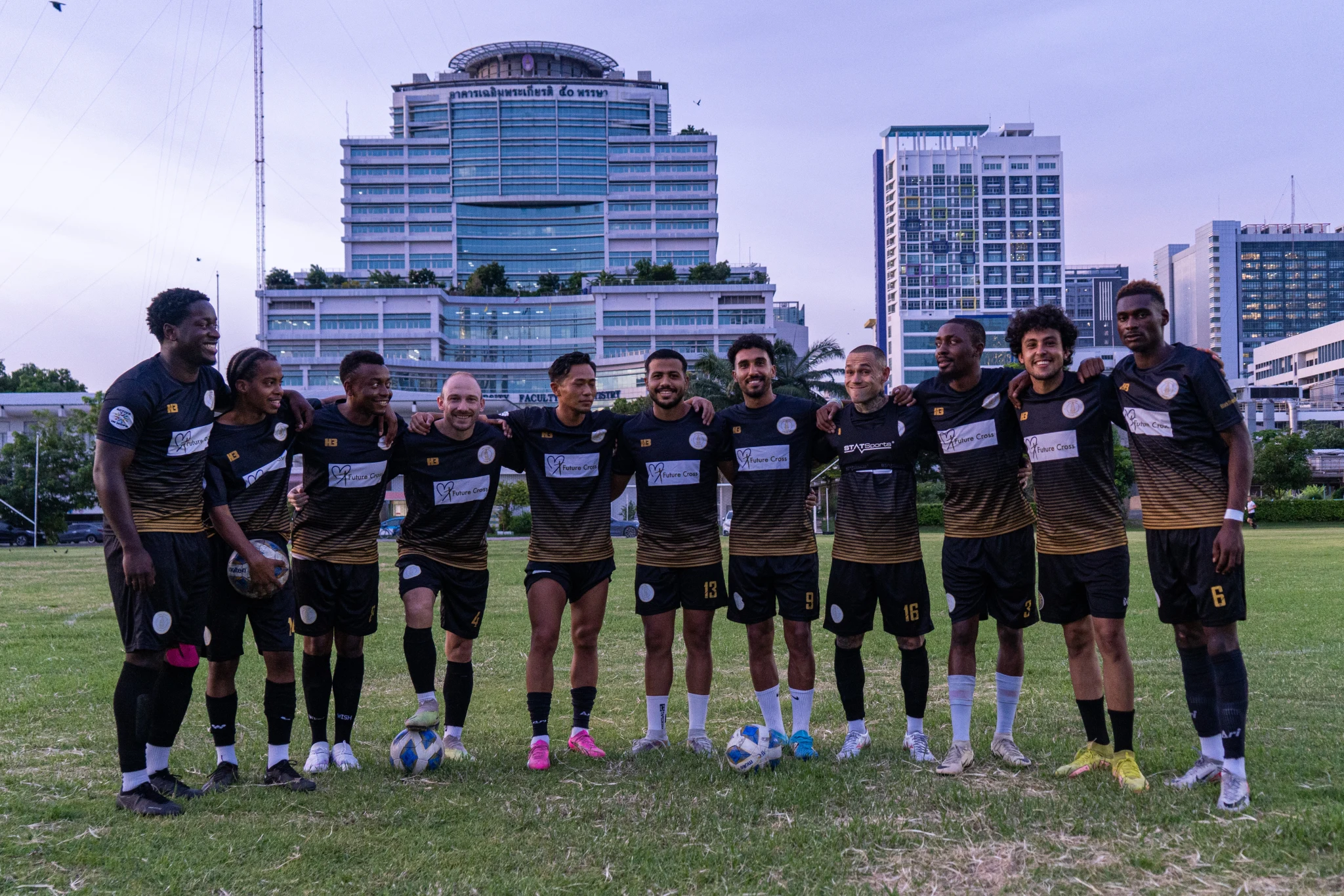 Football players and coaches standing together on a pitch